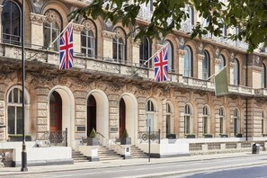 A historic building with ornate architecture, featuring multiple arched windows and a prominent entrance with steps. - The Clermont London, Victoria (London)
