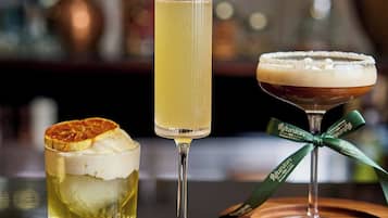 Drei Cocktails auf einer Bar, unscharfer Hintergrund.