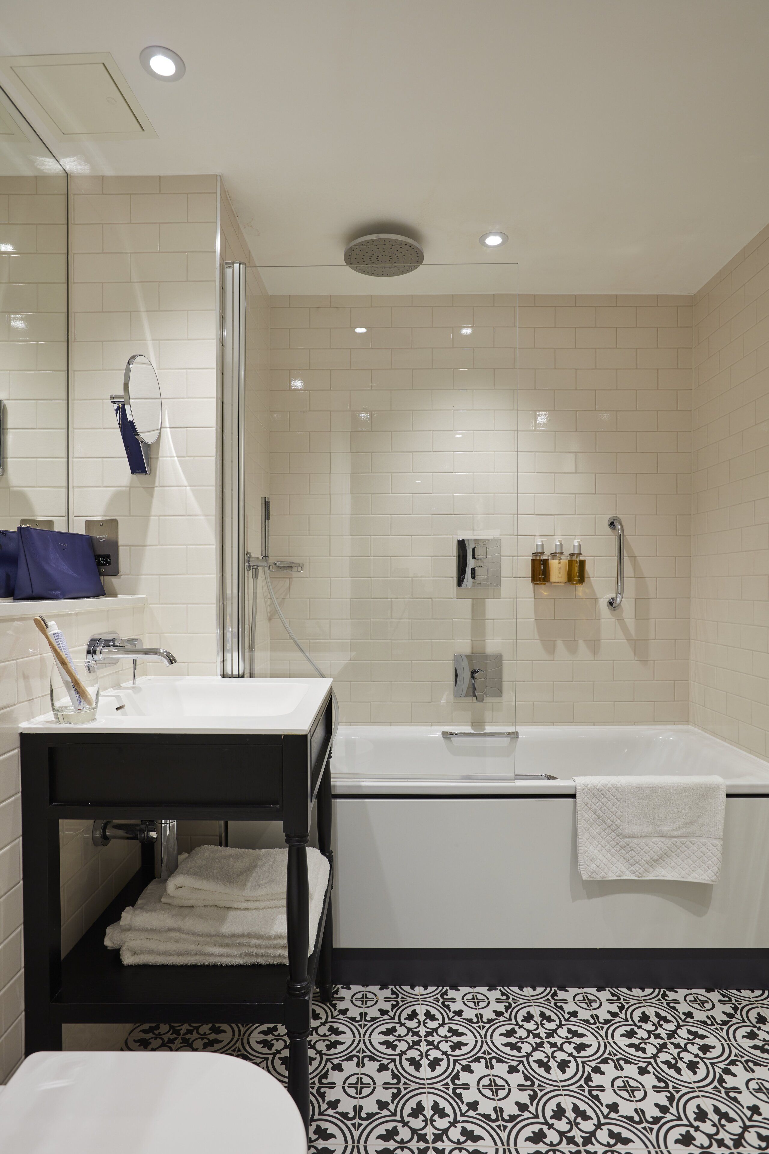 A modern bathroom with a glass shower enclosure, a white sink, and a bathtub.