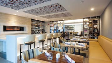 Un restaurante con barra, mesas y chimenea.