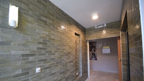 A hallway with green-tiled walls, a wooden floor, and a door leading to another room. - Sleep & Go Brussels Expo (Grimbergen)