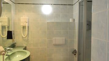A bathroom with a sink, toilet, and shower.