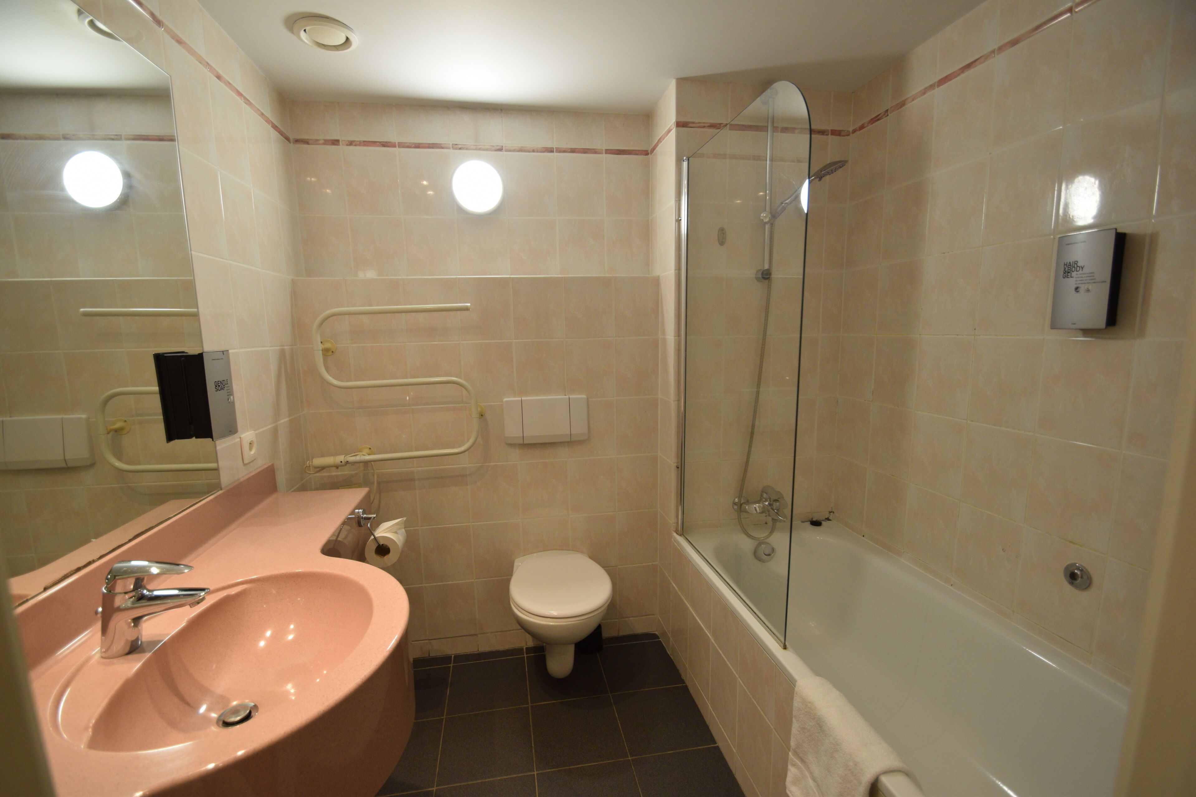 Een badkamer met een wastafel, toilet en douchecabine.