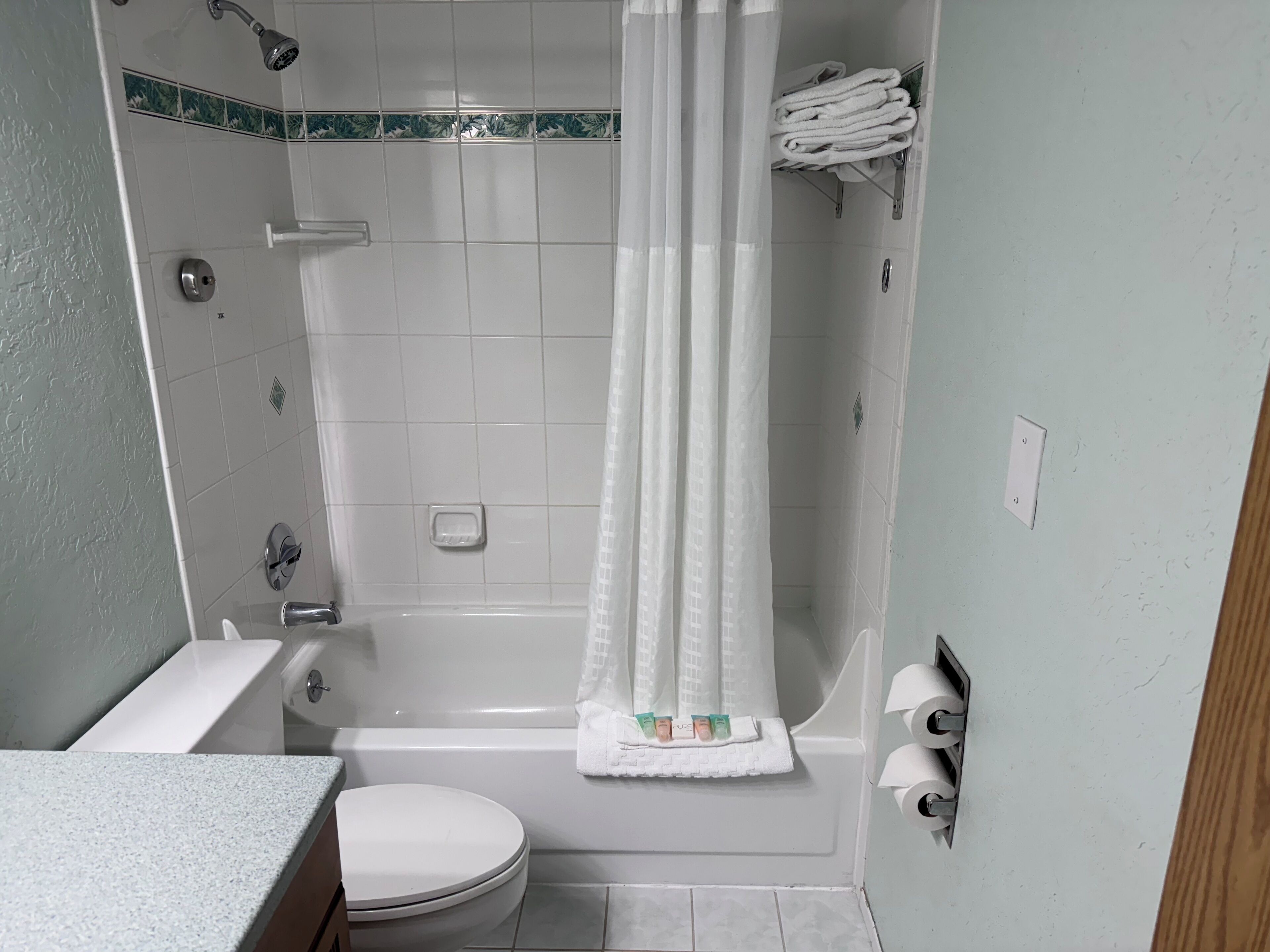 A bathroom with a shower, toilet, and sink.