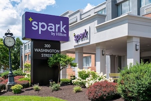 Entrada de un hotel con un letrero que dice 'spark by Hilton' y '300 Washington Street'.
