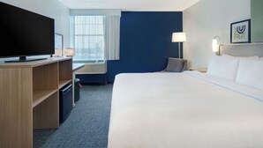 A hotel room with a bed, a television, a desk, and a window. - Spark by Hilton Watertown (Watertown)