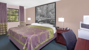 A hotel room with a large bed, a desk, a chair, a television, and a window with curtains. - Super 8 by Wyndham Austell/Six Flags (Austell)
