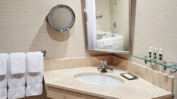 Ein Badezimmer mit Waschbecken, Spiegel, Handtuchhalter und Toilettenartikeln.