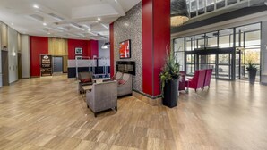 A spacious lobby with a modern design, featuring a reception desk, seating area, and large windows offering views of the outside. - Best Western Plus Waterfront Hotel (Windsor)