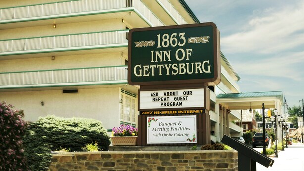 A sign for the 1863 Inn of Gettysburg with a message about guest programs and banquet facilities.