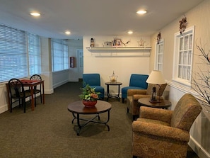 Relax in a cozy living room with a comfortable seating area, wooden coffee table, and a decorative shelf.