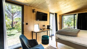 A bedroom with a bed, a TV mounted on the wall, a desk with a lamp, and a chair. - Best Western Sevan Parc Hotel (Pertuis)