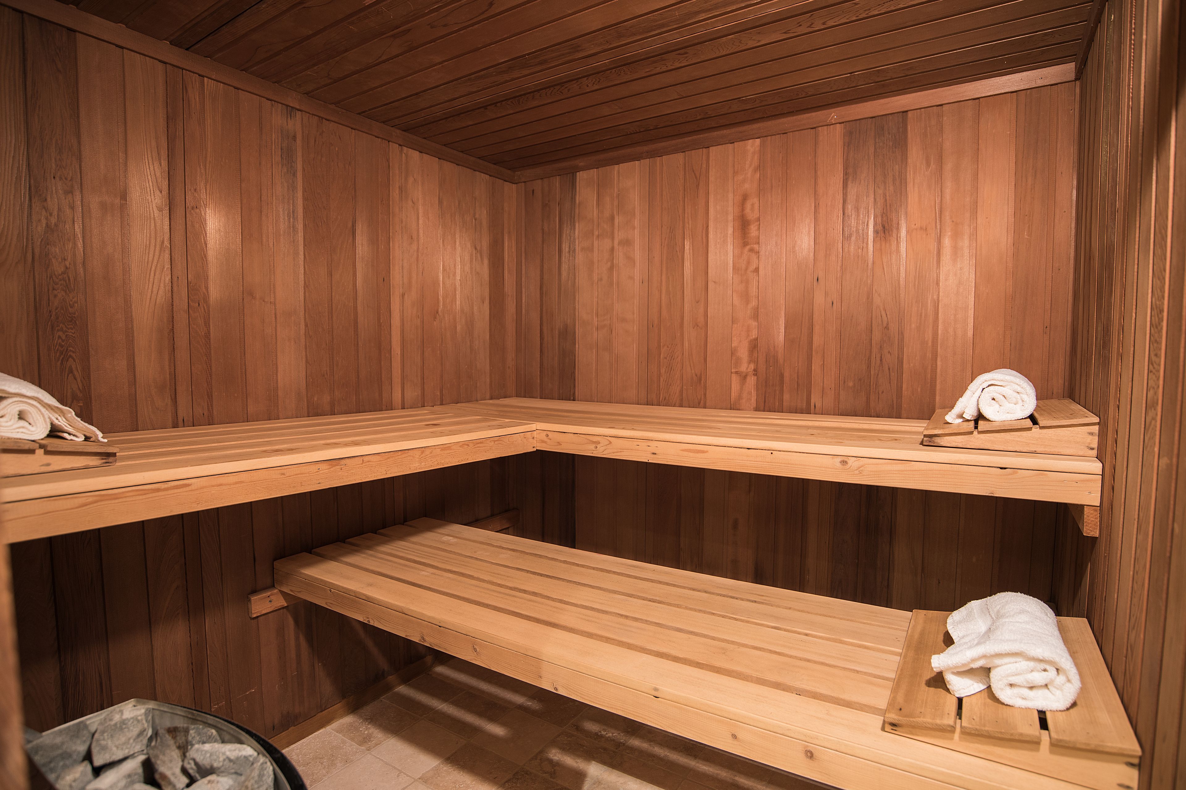 A sauna with wooden benches and towels.