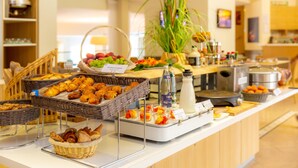 A buffet with various food items, including fruits, pastries, and a beverage station. - Best Western Sevan Parc Hotel (Pertuis)