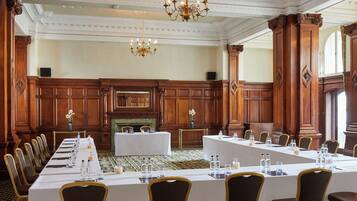 A conference room with a long table, chairs, and a fireplace.
