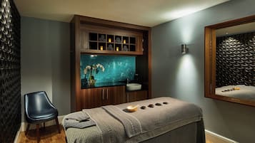 Relax in a serene spa room with a soothing aquarium, comfortable bench, and peaceful ambiance.
