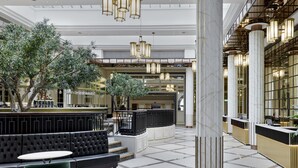 A spacious lobby with a seating area, a reception desk, and a large column.
