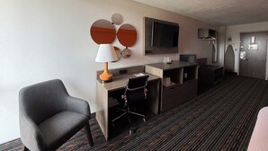 A hotel room with a desk, chair, TV, and a mirror with three circular frames. - Howard Johnson by Wyndham Lexington (Lexington)
