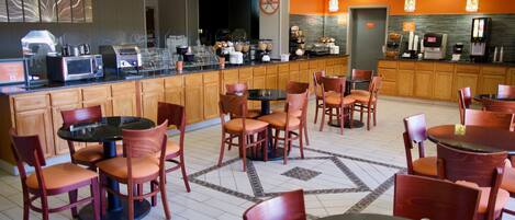 A restaurant with a counter, seating area, and various food and beverage stations.