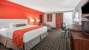 A hotel room with a large bed, two bedside lamps, a desk with a chair, a television, and a window with curtains. - Howard Johnson by Wyndham Lexington (Lexington)
