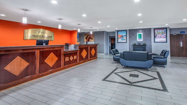 A hotel lobby with a reception desk, seating area, and a fireplace. - Howard Johnson by Wyndham Lexington (Lexington)