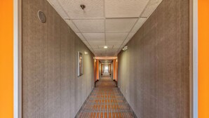 A long, narrow hallway with a patterned carpet and a ceiling with recessed lighting. - Howard Johnson by Wyndham Lexington (Lexington)