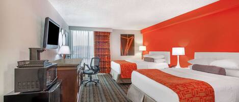 A hotel room with two beds, a desk with a TV, a chair, and a microwave.