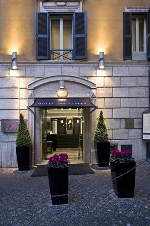 Een hotelentree met een bord waarop 'HOTEL DUCA & ALBA' staat.