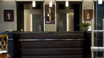 A reception desk with a dark counter and three pendant lights. There are framed pictures on the wall above the desk.