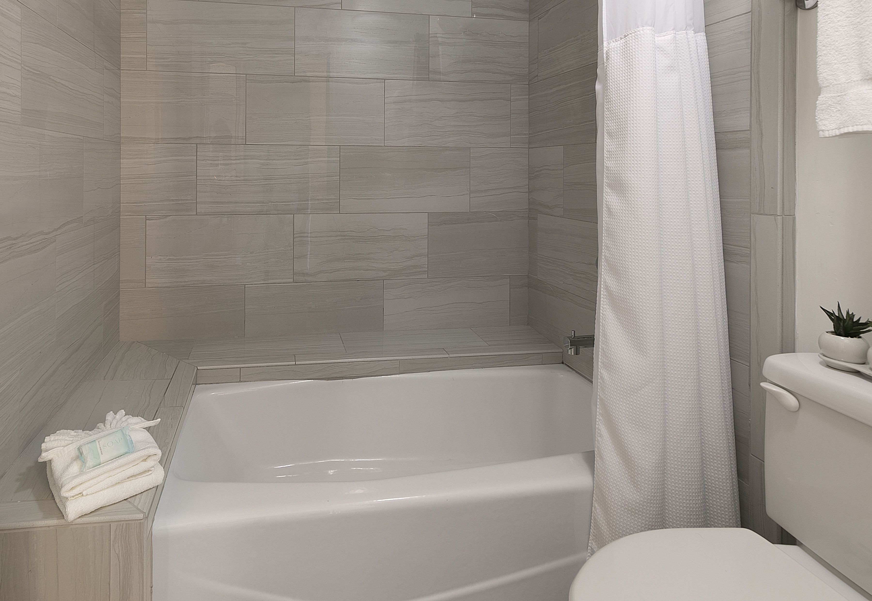 combined shower/bathtub, designer toiletries, hair dryer, towels