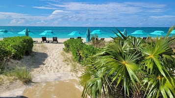 Am Strand, weißer Sandstrand, Liegestühle, Sonnenschirme