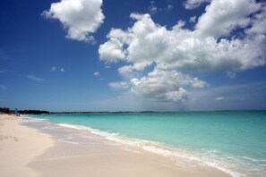 On the beach, white sand, sun loungers, beach umbrellas