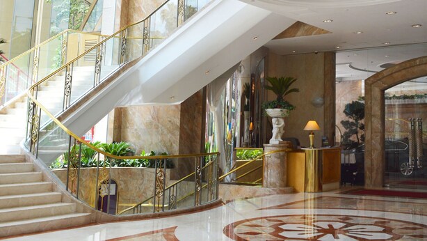 A multi-level interior with a central staircase, marble flooring, and a chandelier. - Regal Hongkong Hotel (Hong Kong)