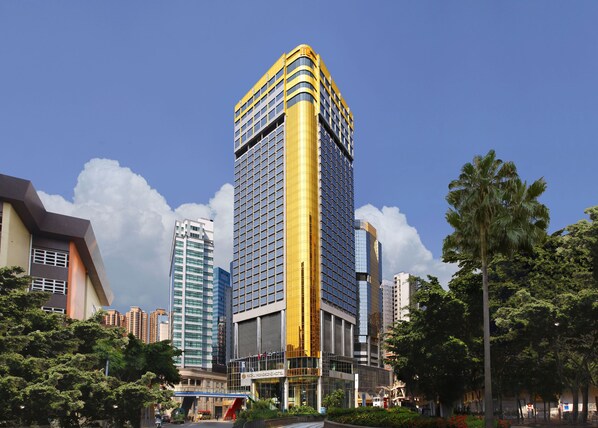 Un hotel moderno con fachada curva, varios pisos y un llamativo detalle amarillo.