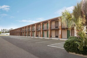 Guest rooms offer balconies overlooking the parking area.
