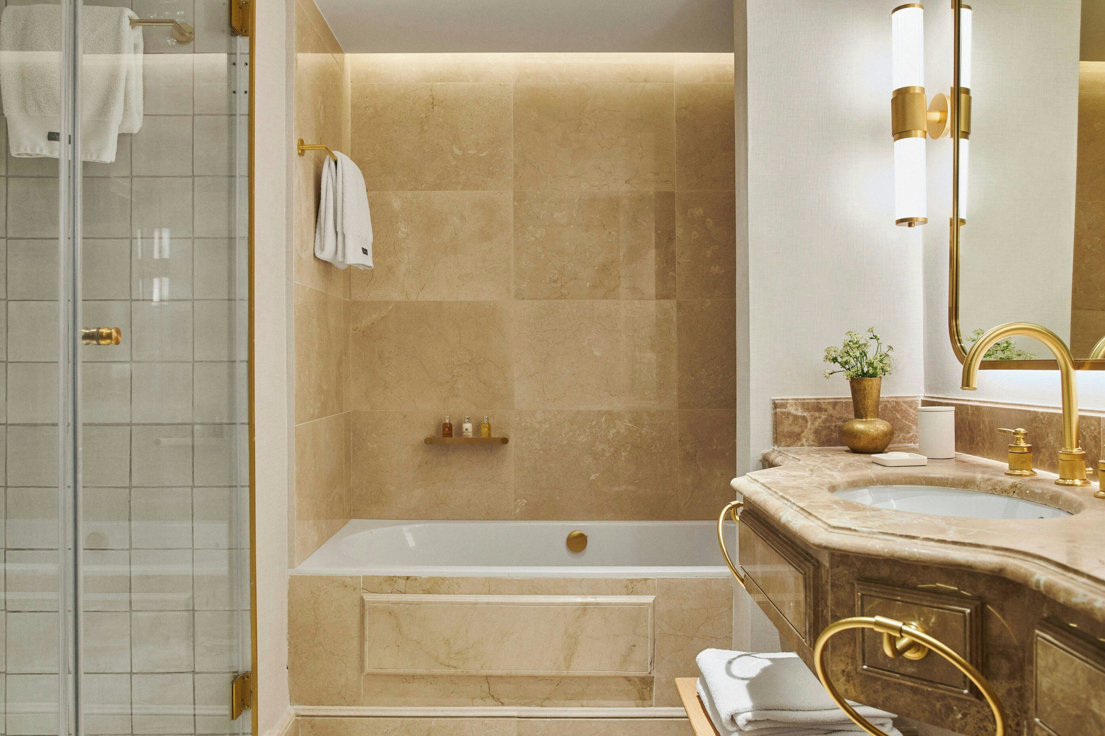 A modern bathroom with a bathtub, a shower, and a vanity with a sink and mirror.