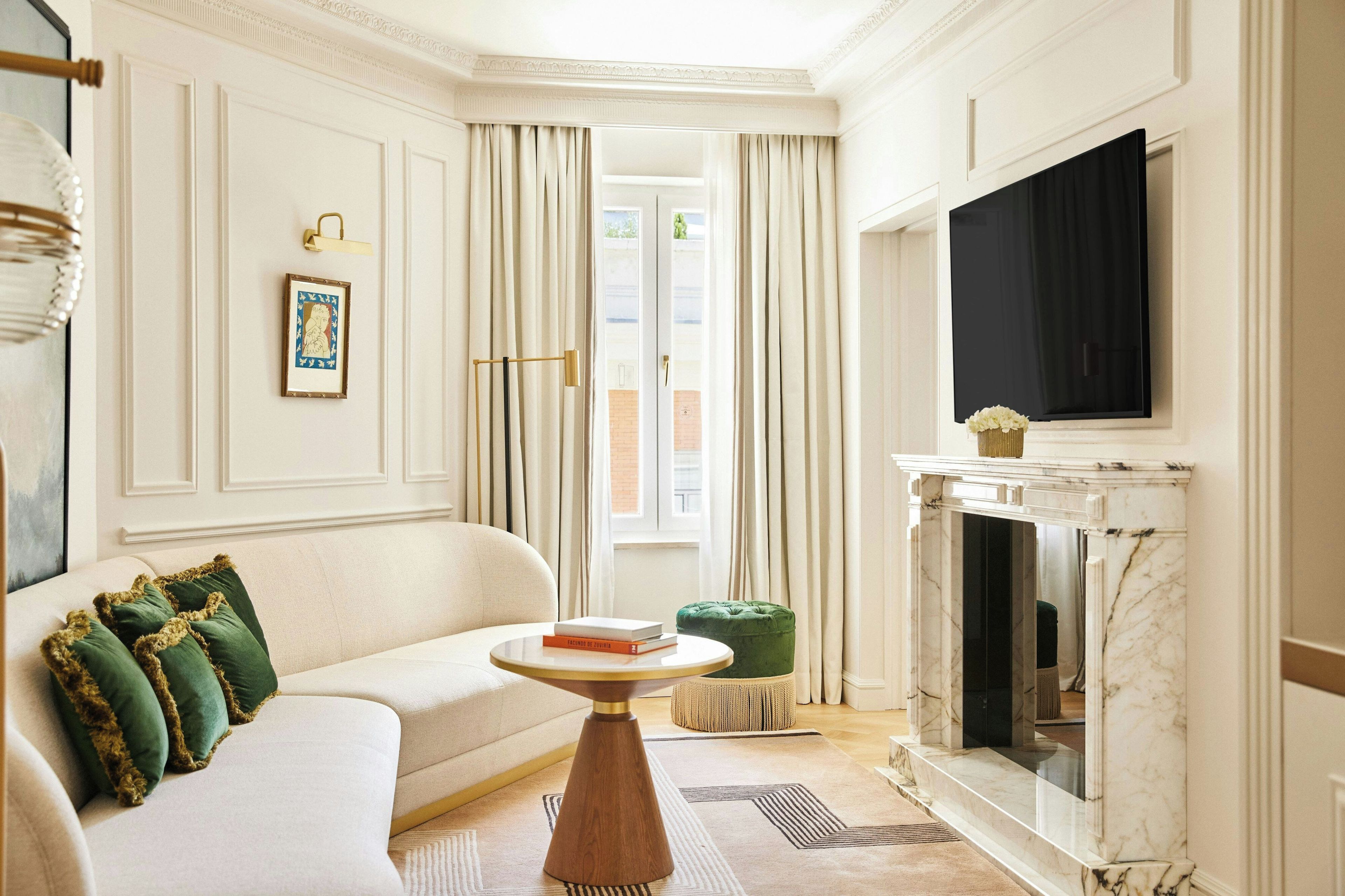 Una sala de estar con sofá, mesa, chimenea y televisor.
