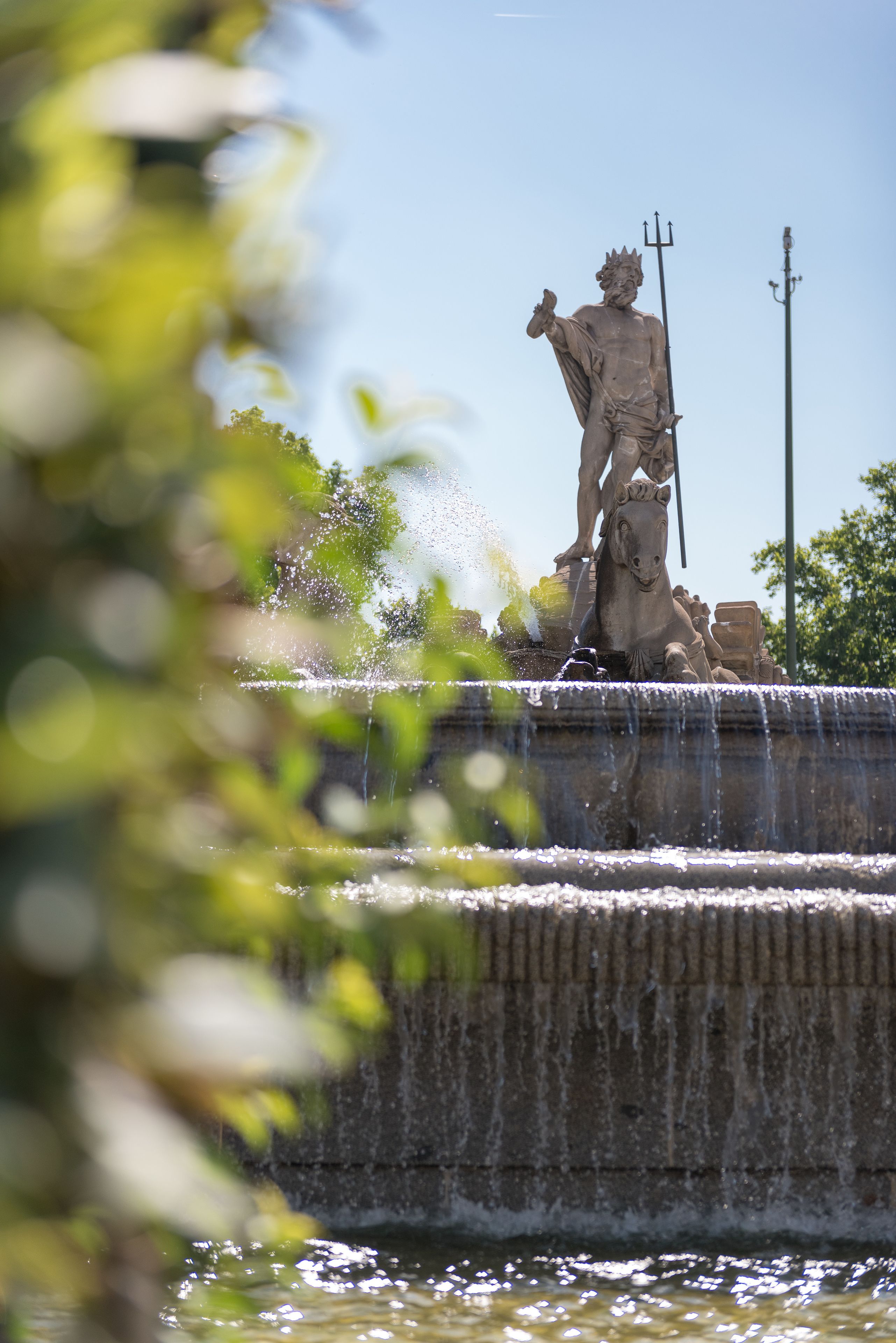 Eine Statue, die eine Figur auf einem Pferd darstellt, steht auf einem Brunnen, aus dessen Basis Wasser fließt.