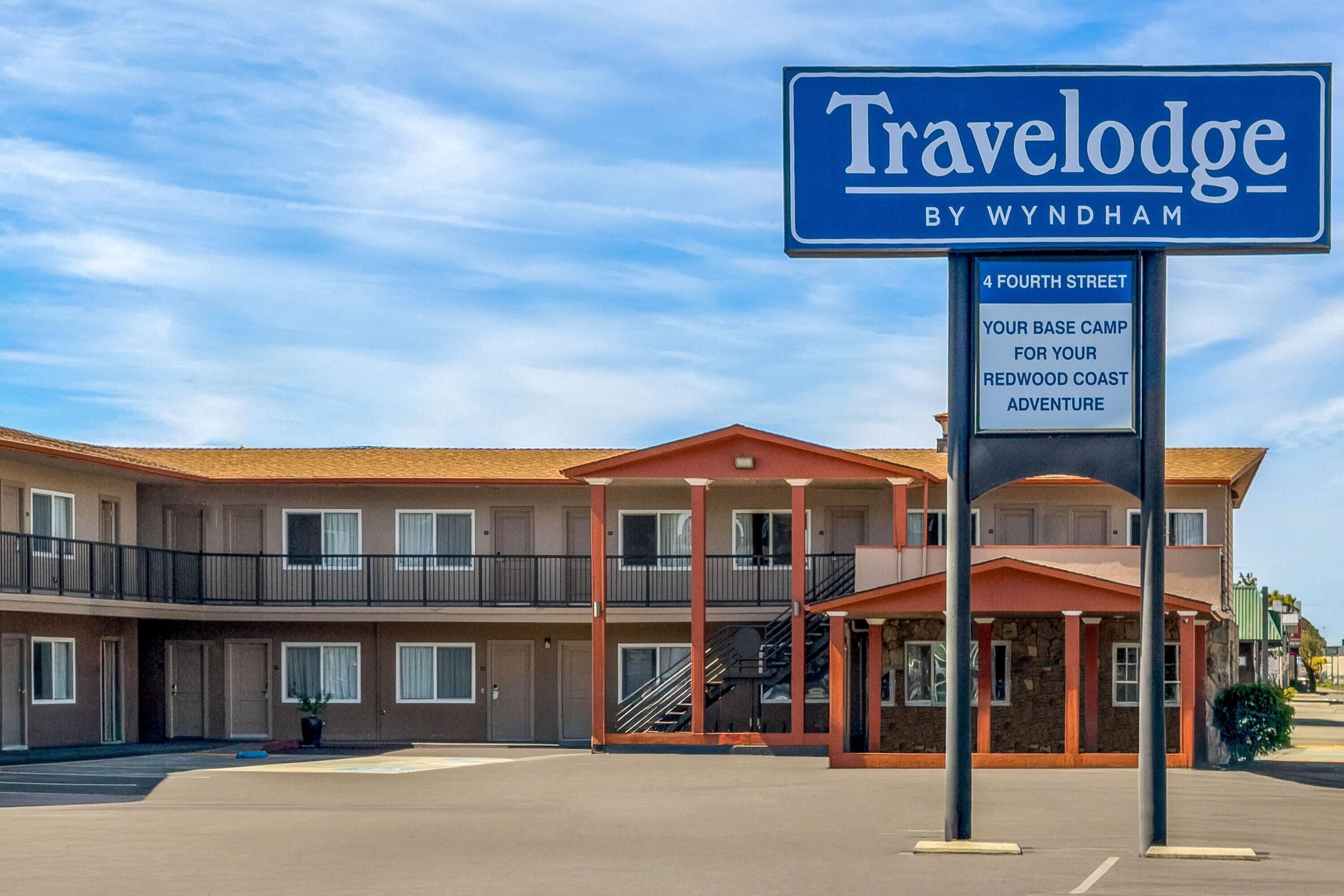 A Travelodge by Wyndham hotel with a two-story structure, a covered entrance, and a sign indicating it's located at 4 Fourth Street.