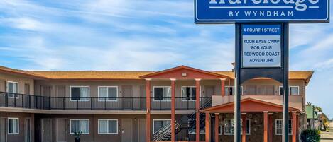 A Travelodge by Wyndham hotel with a two-story structure, a covered entrance, and a sign indicating it's located at 4 Fourth Street.