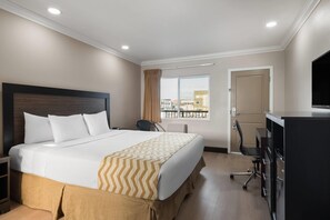 A hotel room with a bed, a desk, a chair, a television, and a window with a view. - Travelodge by Wyndham Eureka (Eureka)