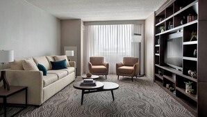 A modern living room with a sofa, two armchairs, a coffee table, and a bookshelf. - Marriott Albany (Albany)