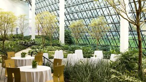 A greenhouse with tables and chairs, surrounded by various plants and trees. - The Westin Southfield Detroit (Southfield)