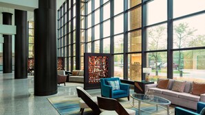 A spacious lobby with large windows, modern seating, and a decorative wall. - The Westin Southfield Detroit (Southfield)