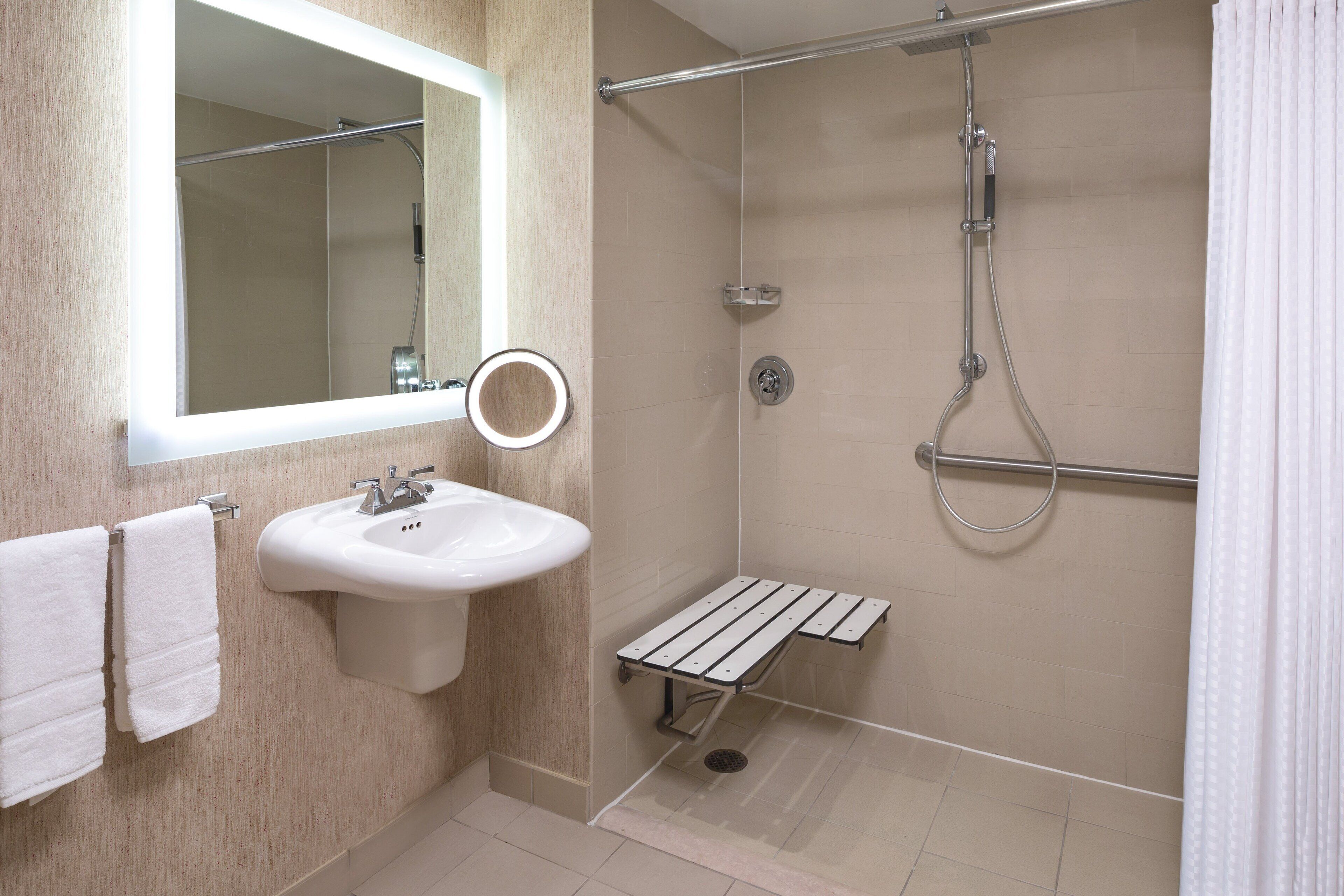 Une salle de bain moderne avec un lavabo, un miroir et une douche.