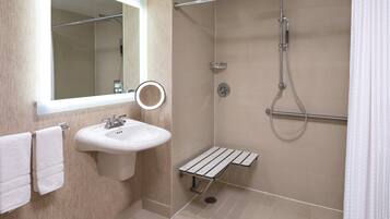 Une salle de bain moderne avec un lavabo, un miroir et une douche.