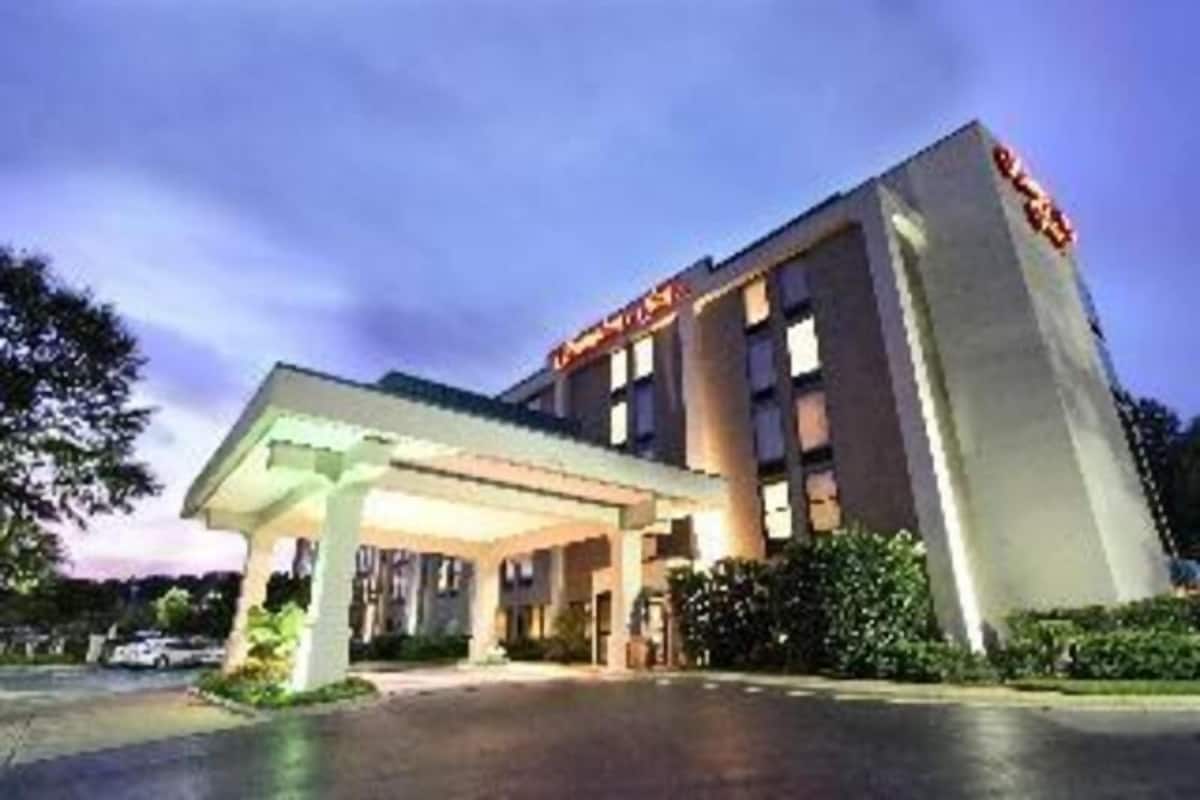 A hotel with a covered entrance, multiple floors, and a prominent sign.