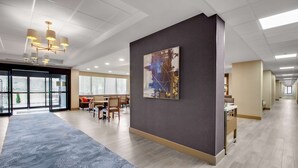 A spacious lobby with a modern chandelier, a large abstract painting, and a patterned carpet. - Hampton Inn Birmingham-Colonnade 280 (Birmingham)