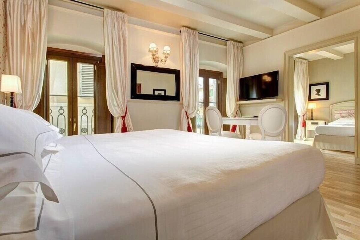 Une chambre d’hôtel avec un grand lit, un bureau, une chaise, une télévision et une salle de bain.