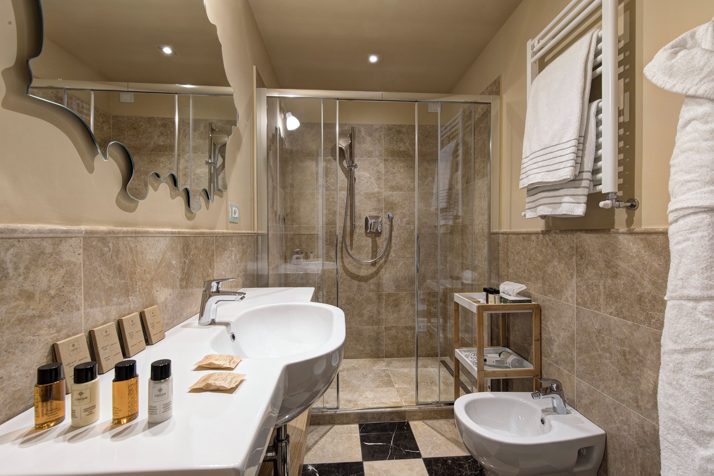 Une salle de bain moderne avec une douche à parois de verre, un meuble-lavabo doté de trois vasques et un bidet.